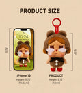 Product size comparison graphic showing a plush character keychain next to an iPhone 13. The text labels the character's height as 5.
