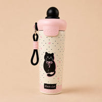 A cute pink and cream insulated water bottle with a black cat illustration, a pink lid, and a black carrying strap, set against a solid beige background.