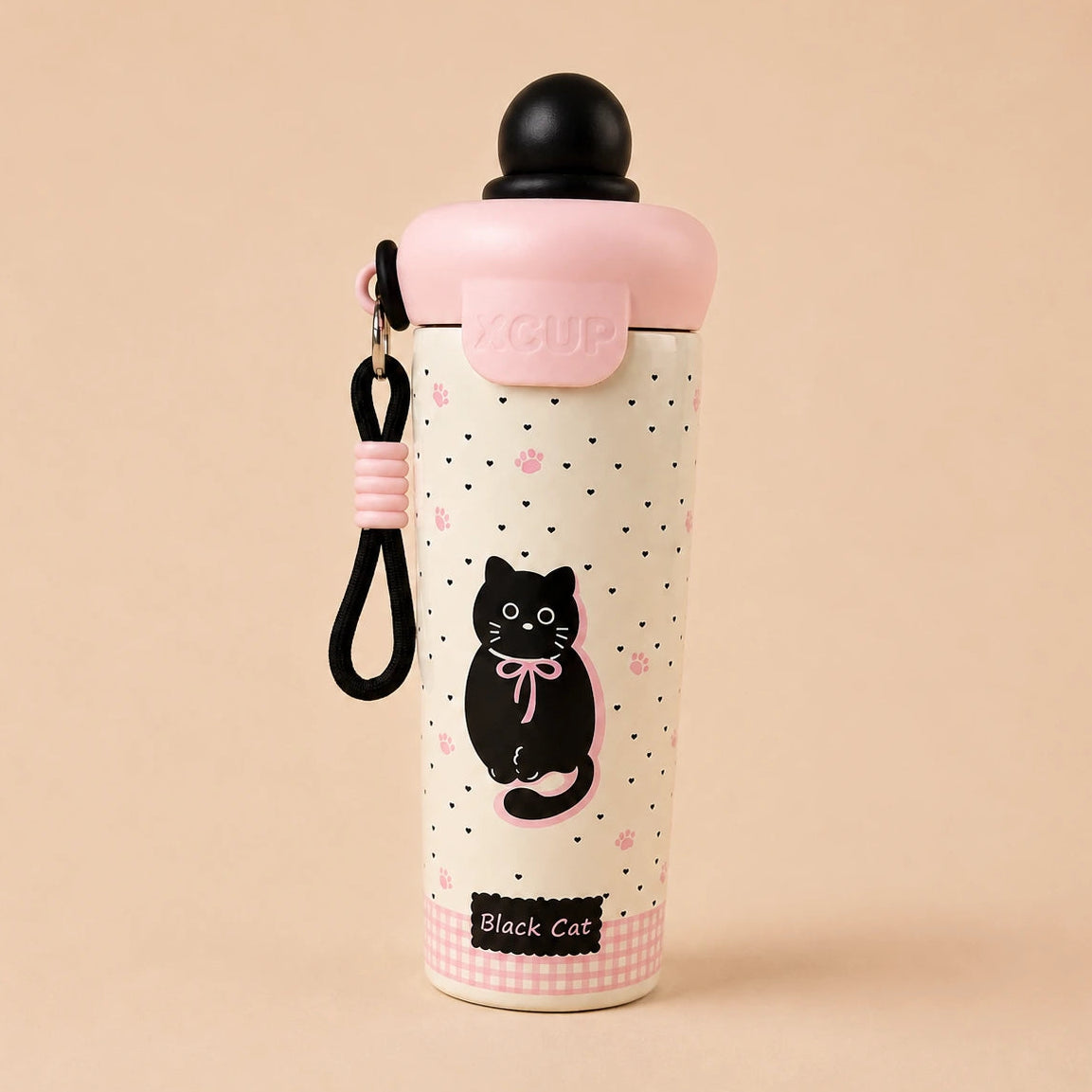 A cute pink and cream insulated water bottle with a black cat illustration, a pink lid, and a black carrying strap, set against a solid beige background.